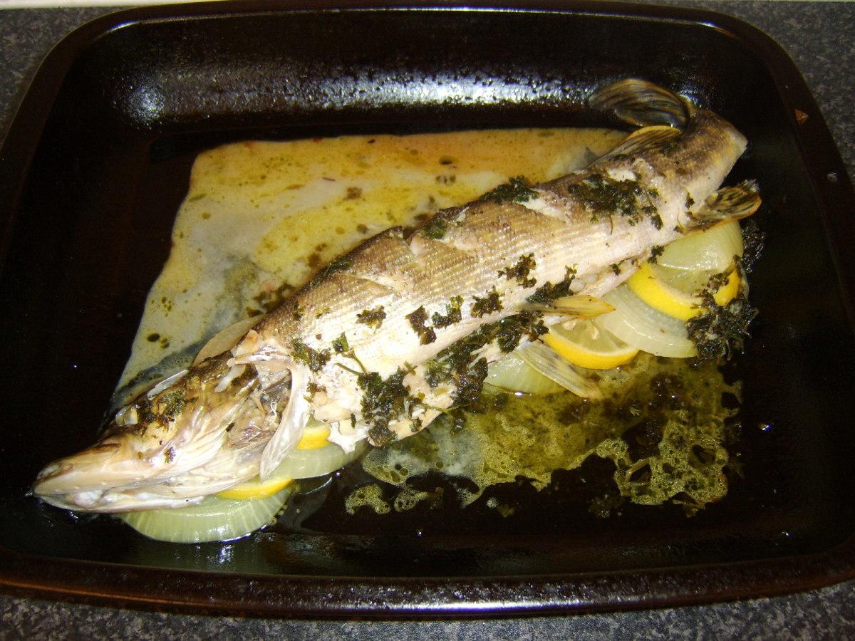 Whole baked northern pike with lemon and dill in a roasting pan