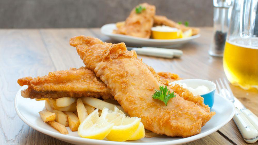 Beer-battered walleye fish and chips with lemon wedges